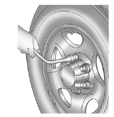 2. If the vehicle has wheel nut caps, loosen them by turning the wheel wrench counterclockwise.