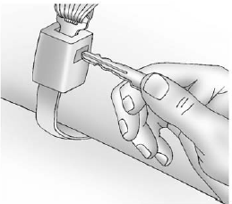 2. Disconnect the rear safety belt mini-latch using a key in the slot on the mini-buckle, and let the belt retract into the headliner.