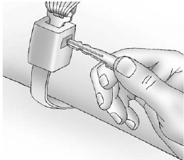 2. Disconnect the rear safety belt mini-latch using a key in the slot on the mini-buckle, and let the belt retract into the headliner.